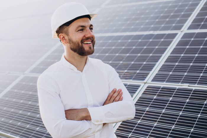 Young architect standing by solar panels